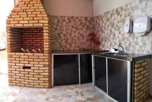 a kitchen with a counter and a brick wall at Chaleville Coqueiro 1001 in Luis Correia