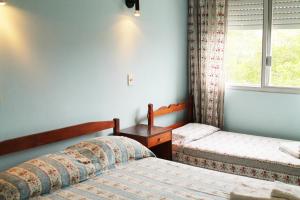 a bedroom with two beds and a window at Edificio Casa Alba in La Paloma