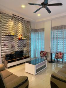 uma sala de estar com um sofá e uma ventoinha de tecto em Sitiawan Modern Teluk Batik Karaoke Snooker BBQ 15PAX em Lumut