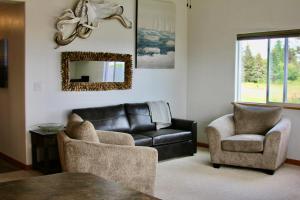 a living room with a leather couch and two chairs at Seafarer Suites in Homer