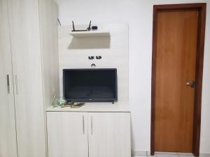 a tv sitting on top of a white cabinet at Chaleville Coqueiro 1001 in Luis Correia