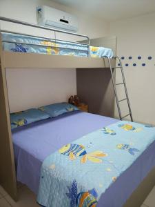 a bedroom with two bunk beds with a blue bedspread at Chaleville Coqueiro 1001 in Luis Correia