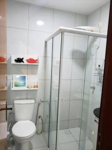 a bathroom with a toilet and a glass shower at Chaleville Coqueiro 1001 in Luis Correia