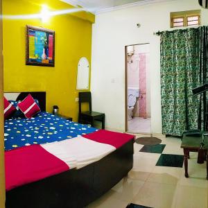 a bedroom with a bed and a bathroom at Satkar Hotel in Jaipur