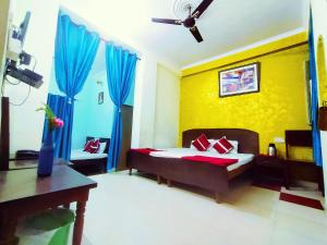 a bedroom with a bed and blue drapes at Satkar Hotel in Jaipur