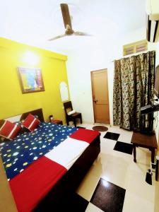a bedroom with a bed with a red white and blue blanket at Satkar Hotel in Jaipur