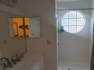 La salle de bains est pourvue d'une douche, d'un lavabo et d'un miroir. dans l'établissement Somerset Villas 84, à Kissimmee