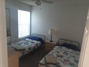 two beds in a small room with a window at Somerset Villas 84 in Kissimmee