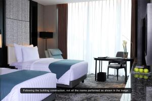 Letto o letti in una camera di JHL Solitaire Gading Serpong