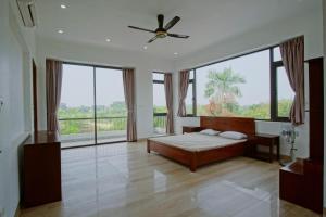 a bedroom with a bed and a large window at Tản Đà Lake View Ba Vì - Venue Travel in Hanoi +17 photos