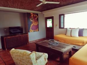 een kamer met 2 bedden en een tafel en een bank bij Casa Maria en La Manzanilla in La Manzanilla