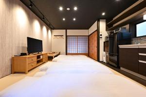 - une chambre avec un grand lit et une télévision dans l'établissement 行灯離れ京都五条 Andon Hanare Kyoto Gojo, à Kyoto