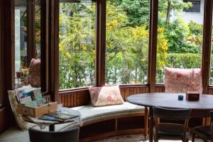 asiento junto a la ventana en una habitación con mesa en R&J Guesthouse, en Yuanshan