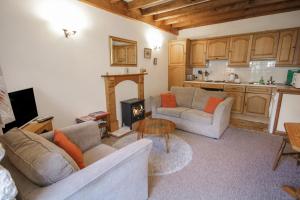 a living room with two couches and a fireplace at Royal Oak Farm Cottage in Betws-y-coed