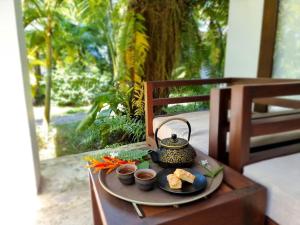 a tray with a tea pot and vegetables on a table at Sahaa Beach Resort in Sihanoukville