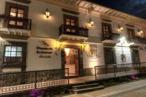 un edificio blanco con balcones en una calle por la noche en Land of the Sun Hotel & Spa, en Cotacachi