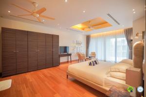 a bedroom with a large bed with a ceiling fan at Teetara Villa Patong in Patong Beach