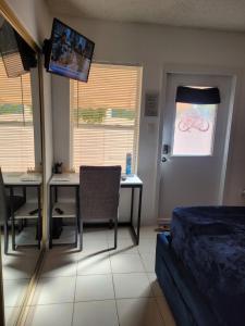 Dormitorio con cama, escritorio y TV en Welcome Heart and Reliable Heart Vacation Houses, en Miami