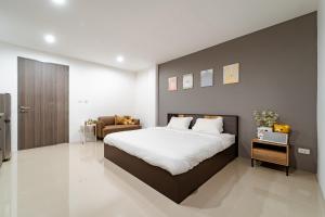 een slaapkamer met een groot bed en een bank bij My Space @ Chaosua69 in Ban Pak Khlong Khwang