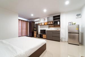 ein Schlafzimmer mit einem Bett und eine Küche mit einem Kühlschrank in der Unterkunft My Space @ Chaosua69 in Ban Pak Khlong Khwang