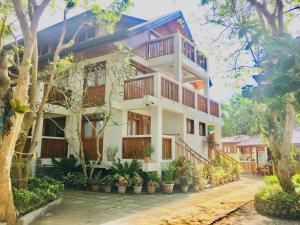a white building with wooden balconies and plants at Pahiluna Guesthouse in Panglao Island
