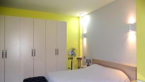 ティラナにあるCentral Apartments Shoshiのベッドルーム1室(白いベッド1台付)と黄色い壁