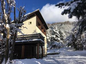 een blokhut in de sneeuw met bomen bij Chalet Nicouski in La Salle Les Alpes