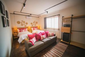 a bedroom with two beds and a couch with pink pillows at Casa Rosamate in Oaxaca City