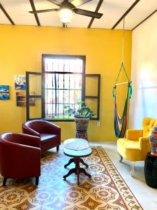uma sala de estar com cadeiras e uma mesa em La Casa Rosal, Pool em Campeche