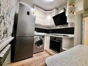 a kitchen with a stainless steel refrigerator and a dishwasher at Квартира на Тулебаева in Almaty