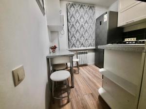 a small kitchen with a counter and stools in it at Квартира на Тулебаева in Almaty