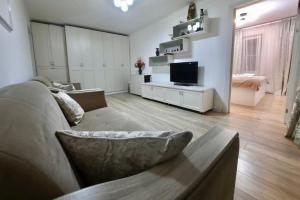 sala de estar con sofá y TV en Квартира на Тулебаева en Almaty