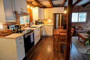 a kitchen with white cabinets and a wooden floor at 4 Mile Creek Cabin (Creekside) in Nelson