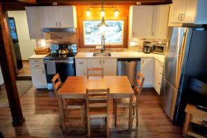 a kitchen with a wooden table and a sink at 4 Mile Creek Cabin (Creekside) in Nelson