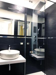 a black bathroom with a sink and a mirror at Hotel Gioia in Florence