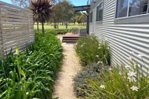 - un jardin à côté d'une maison avec une terrasse dans l'établissement Fairways 1, à Coles Bay