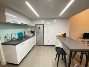 a kitchen with white cabinets and a black counter top at KL Sentral Loft , EST Bangsar #2, LRT in Kuala Lumpur