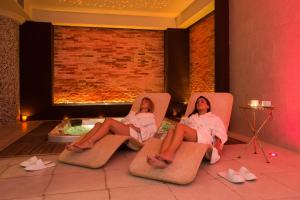 two women sitting in chairs in a room with a tub at Essence Sicily - Marina Holiday Hotel & Spa in Balestrate
