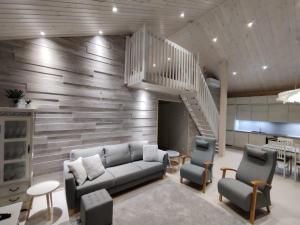sala de estar con sofá y sillas y escalera en Villa Sirius Sieri, nice Log-Cottage by the lake, en Rovaniemi
