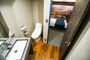 a small bathroom with a toilet and a sink at Hotel S-Presso Namba in Osaka