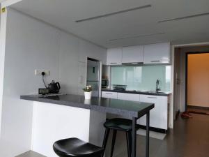 吉隆坡的住宿－KL Sentral Loft, EST Bangsar #1, LRT，厨房配有柜台和2把凳子