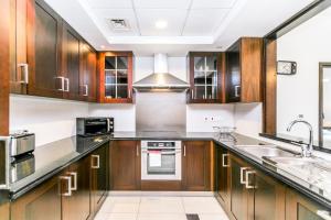 a kitchen with wooden cabinets and a sink at 1BR Boulevard View 29 Blvd T2 Downtown in Dubai
