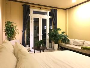 um quarto com uma cama, um sofá e uma janela em CozyNook Boutique Apartments - 3 thang 2 Street em Da Lat