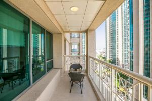 a balcony with chairs and a table and some buildings at 1BR Boulevard View 29 Blvd T2 Downtown in Dubai