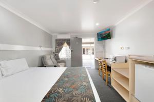 a bedroom with a bed and a kitchen and a desk at Best Western Bundaberg City Motor Inn in Bundaberg +28 photos
