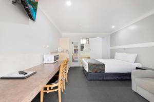 a bedroom with a bed and a desk in a room at Best Western Bundaberg City Motor Inn in Bundaberg