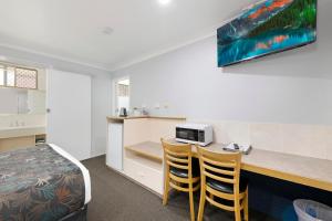 a hotel room with a bed, desk and television at Best Western Bundaberg City Motor Inn in Bundaberg