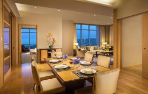 a dining room and living room with a table and chairs at Somerset Grand Central Dalian in Dalian