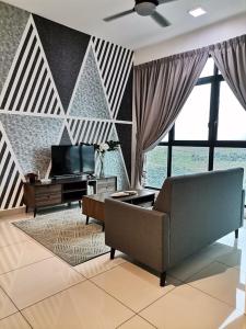 een woonkamer met een bank en een televisie bij Conezion Residence Putrajaya nearby IOI City Mall in Putrajaya