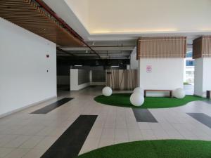 an office lobby with a green rug and a bench at Conezion Residence Putrajaya nearby IOI City Mall in Putrajaya